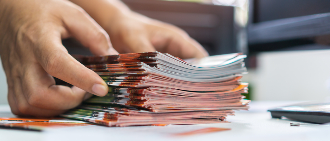 Handen plaatsen stapel flyers op tafel