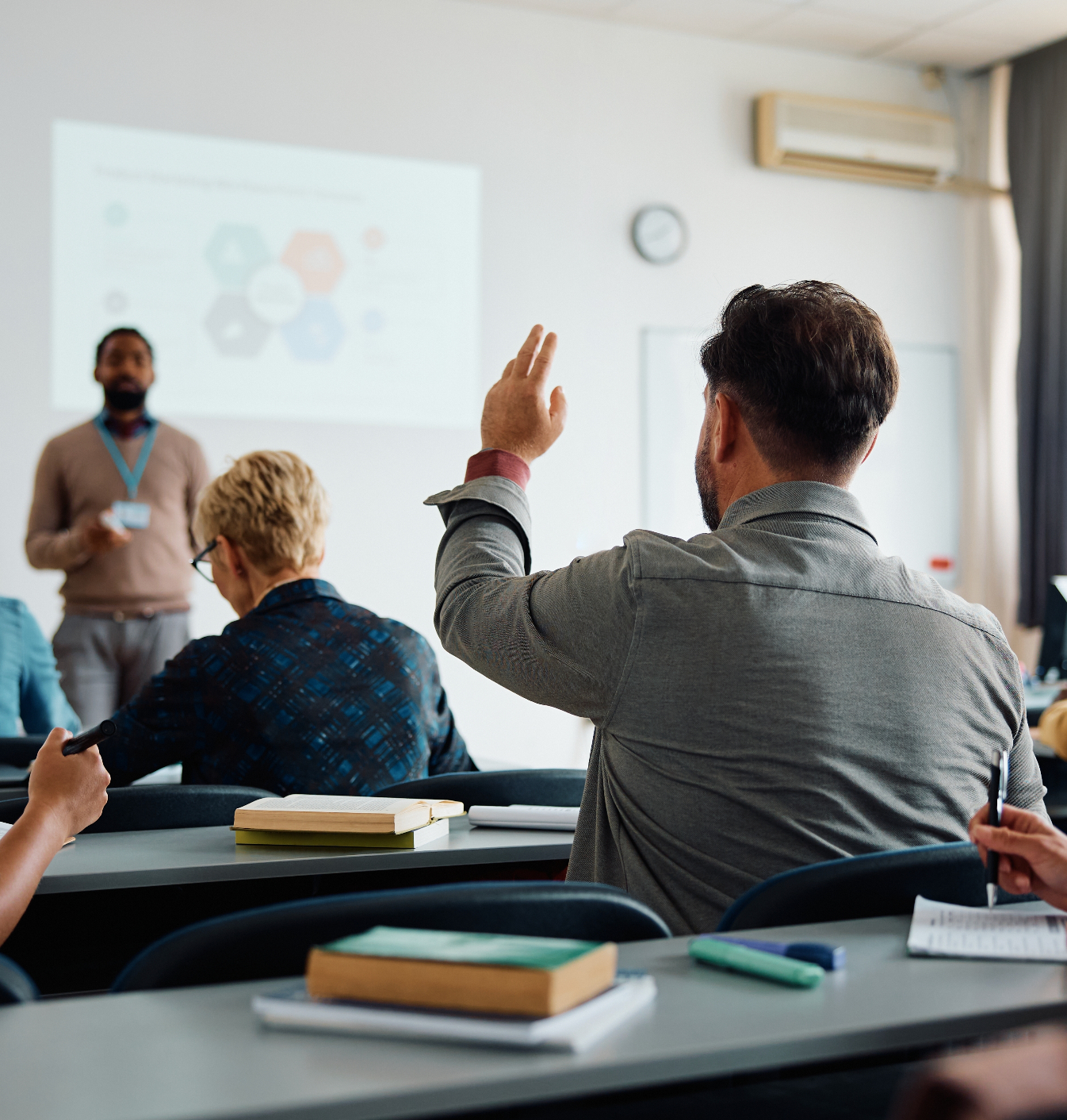 man in klas steekt hand op